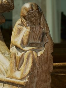 Carved figure on arm-rest.