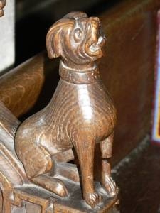 Arm rest carving. Fierce looking dog with collar.