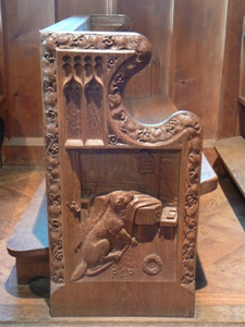 Bench end carving of dog by his master's coffin
