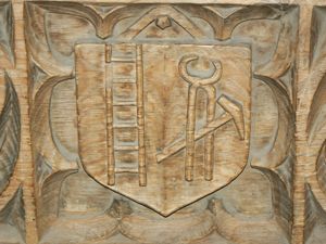 Close-up of the carving showing the ladder, hammer and pincers.